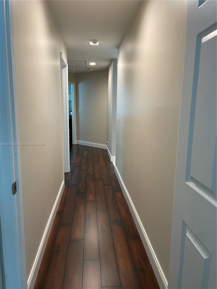 Hallway featuring wood-finish flooring, recessed lighting, and neutral wall paint
