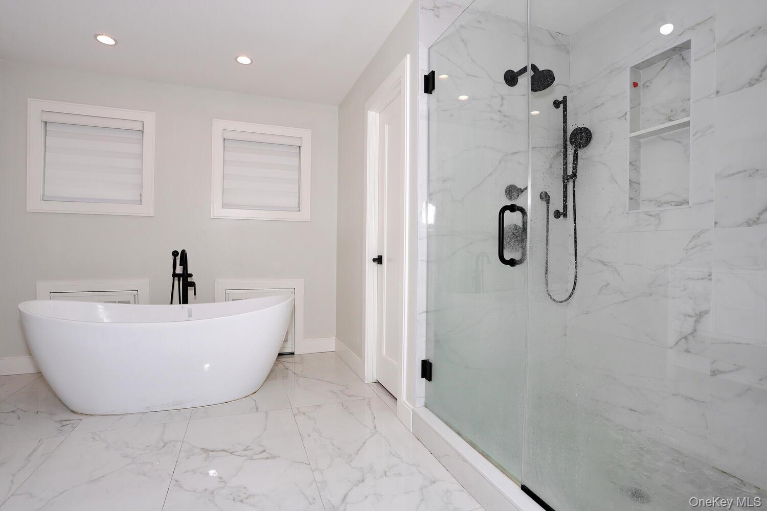 Full bathroom featuring a soaking tub, light marble finish flooring, a marble finish shower, and recessed lighting