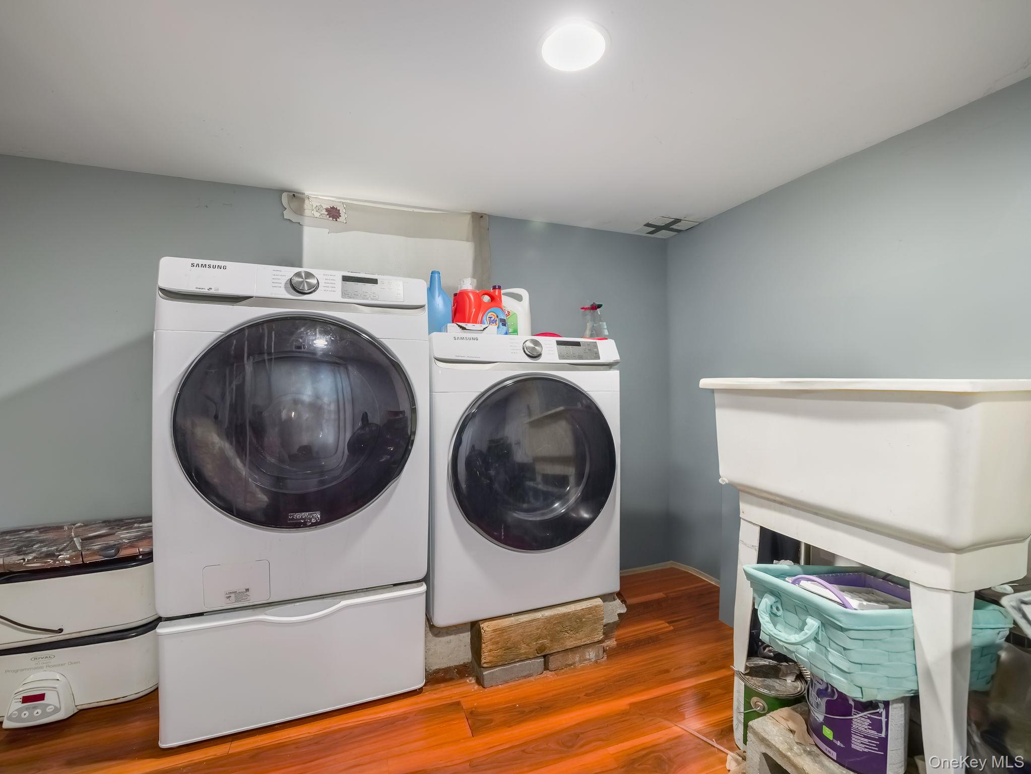 Laundry area featuring wood finished floors and separate washer and dryer