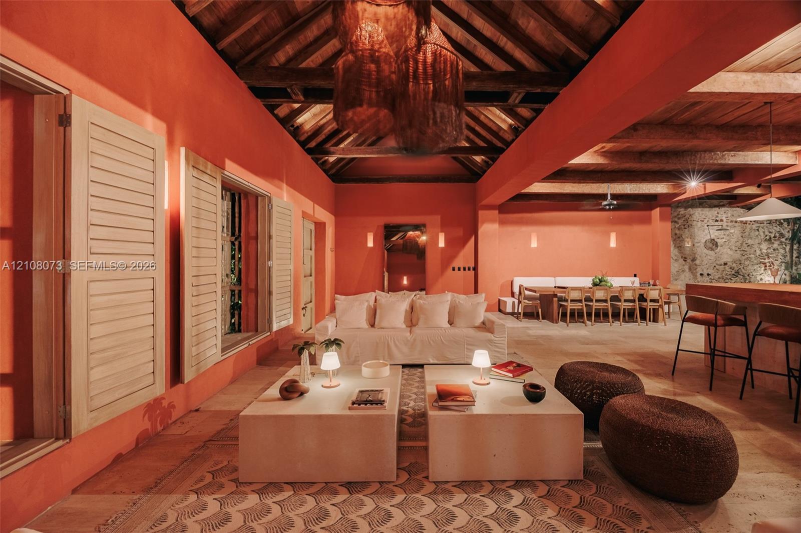 Exposed wood-beam vaulted ceilings, large louvered wooden shutters, stone flooring, and built-in masonry counters