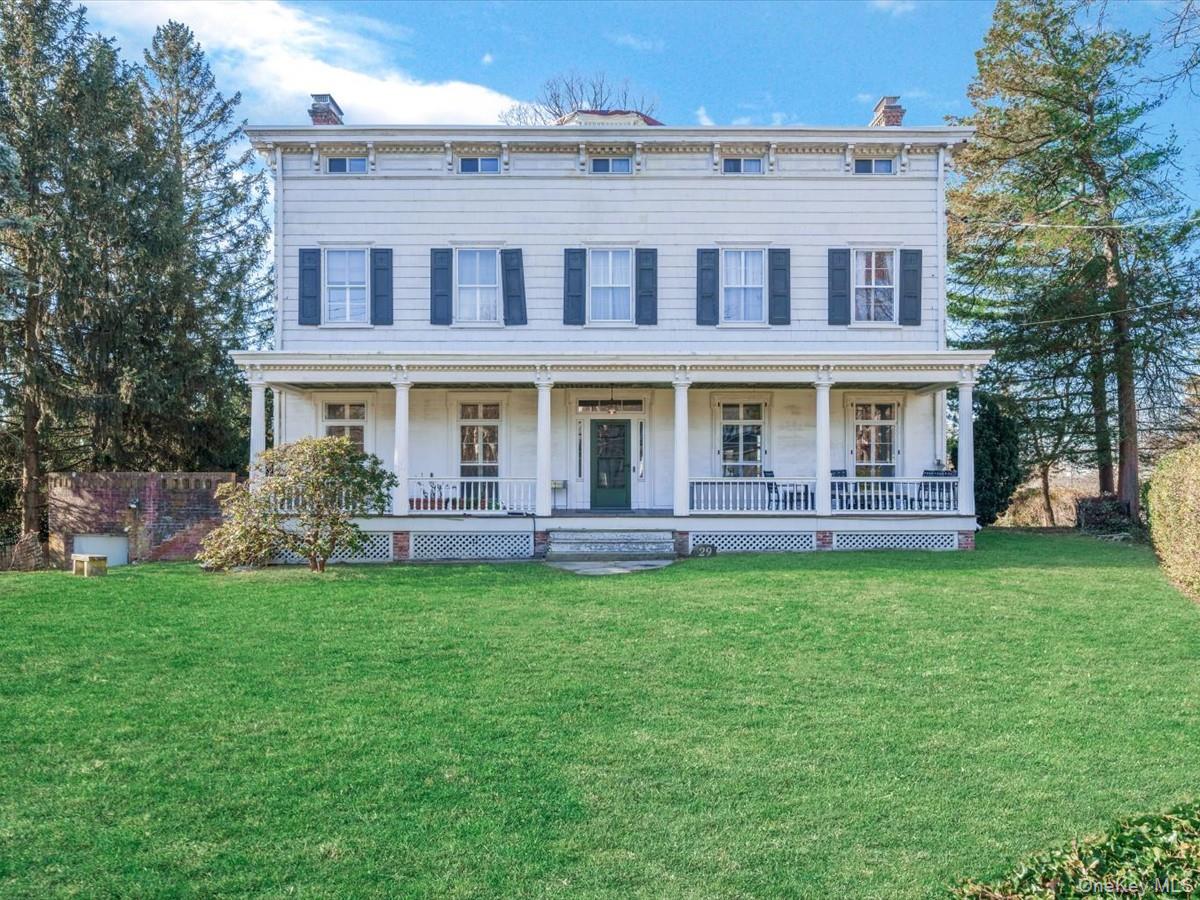 Italianate house featuring a chimney, a front lawn, and a porch