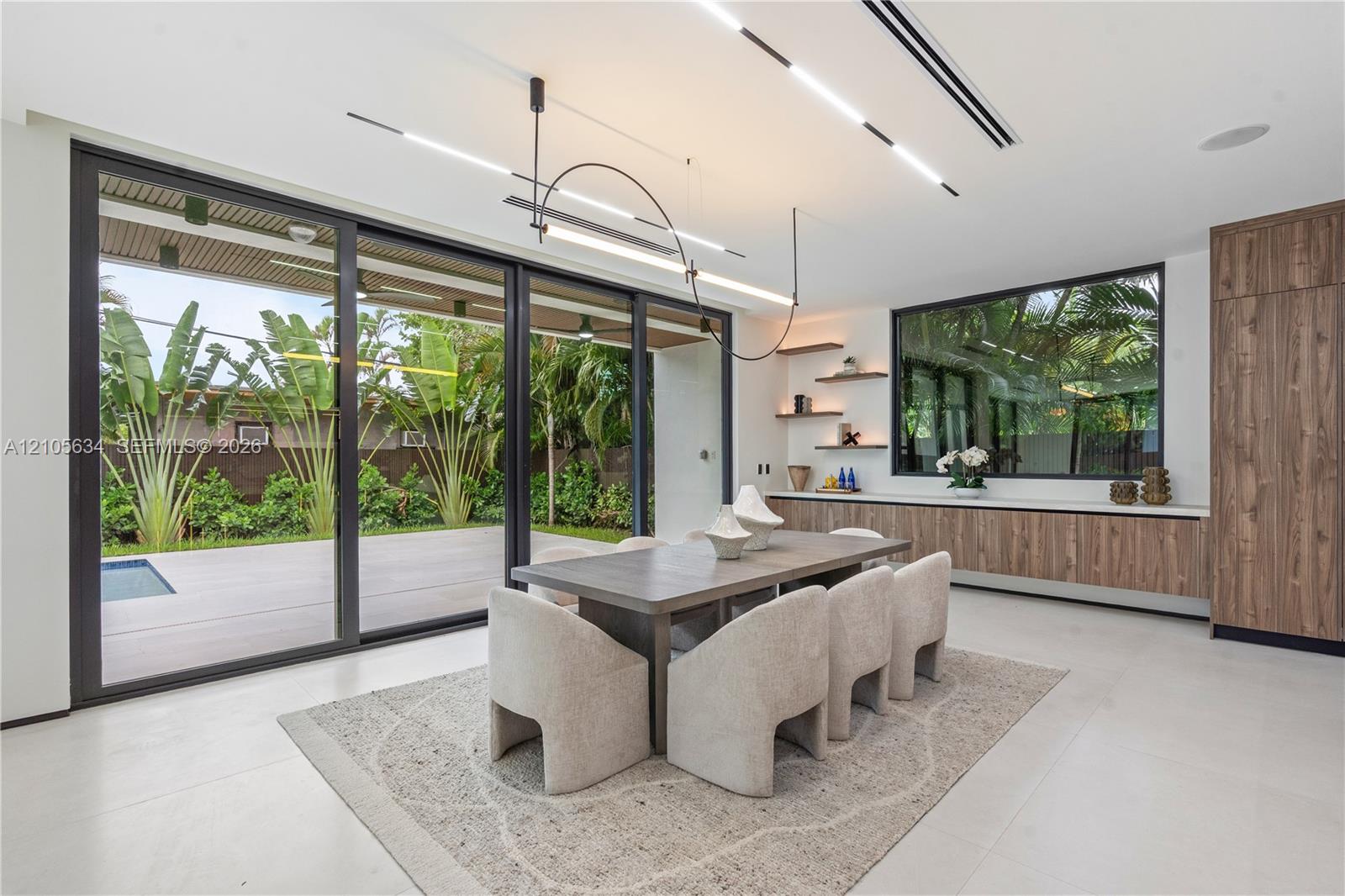 Large-scale sliding glass doors, contemporary linear LED lighting, custom wood-finish cabinetry, floating wall shelves, and expansive smooth-finish fl