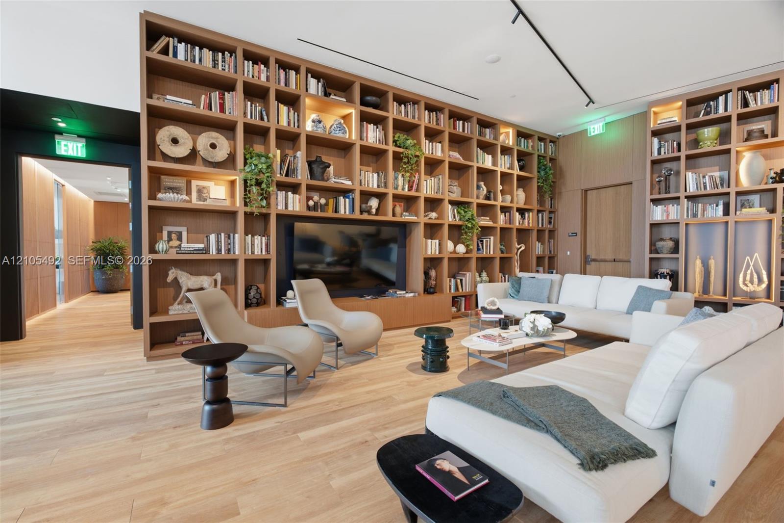 Floor-to-ceiling built-in wood shelving, integrated recessed lighting, and wood-finish flooring