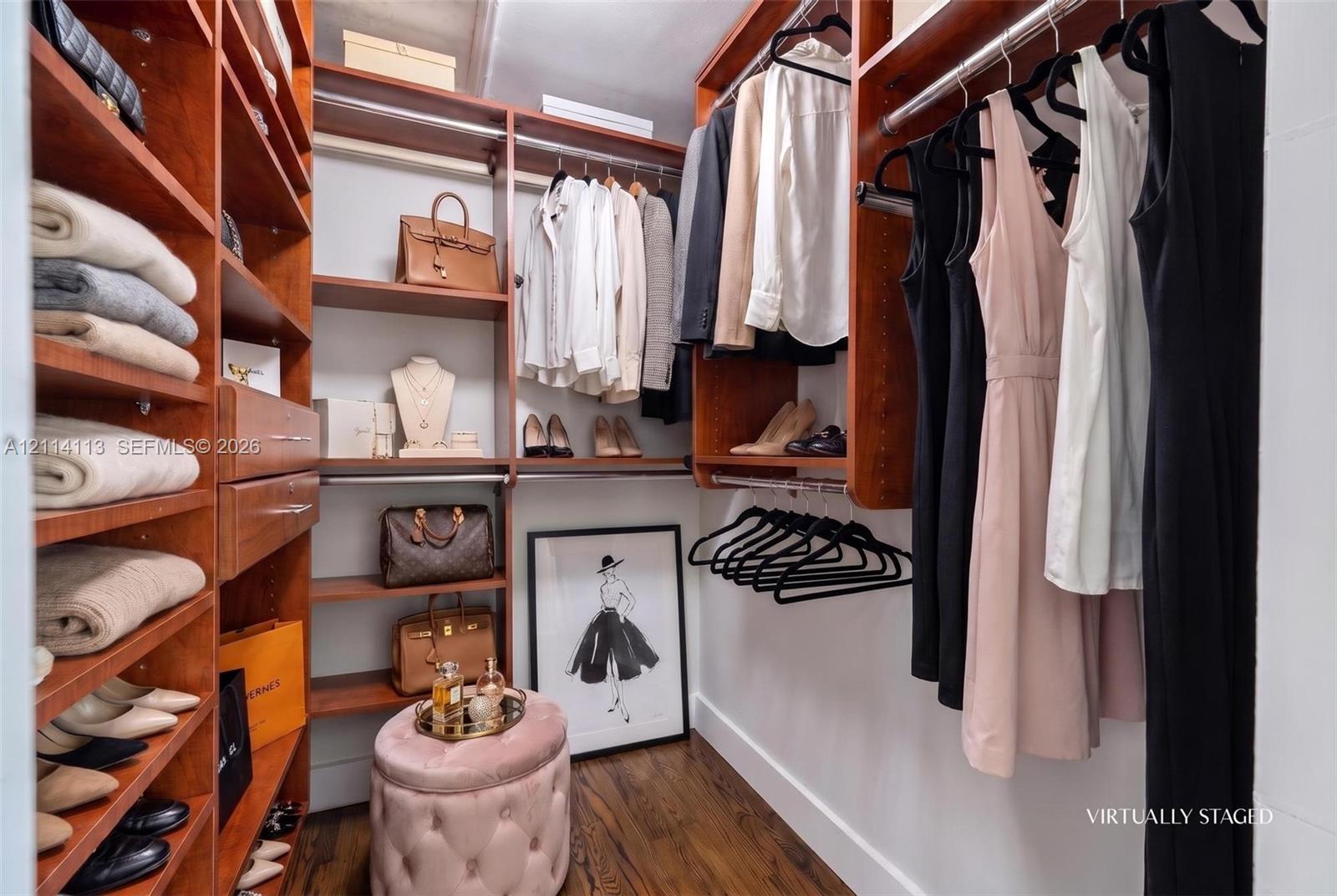 Custom walk-in closet featuring floor-to-ceiling wooden cabinetry, built-in shelving