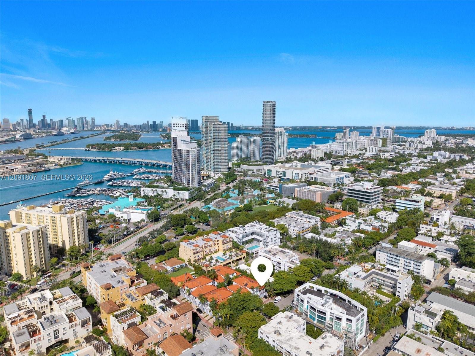 Aerial perspective of urban locale featuring proximity to waterfront, metropolitan skyline, marina, and major bridge infrastructure