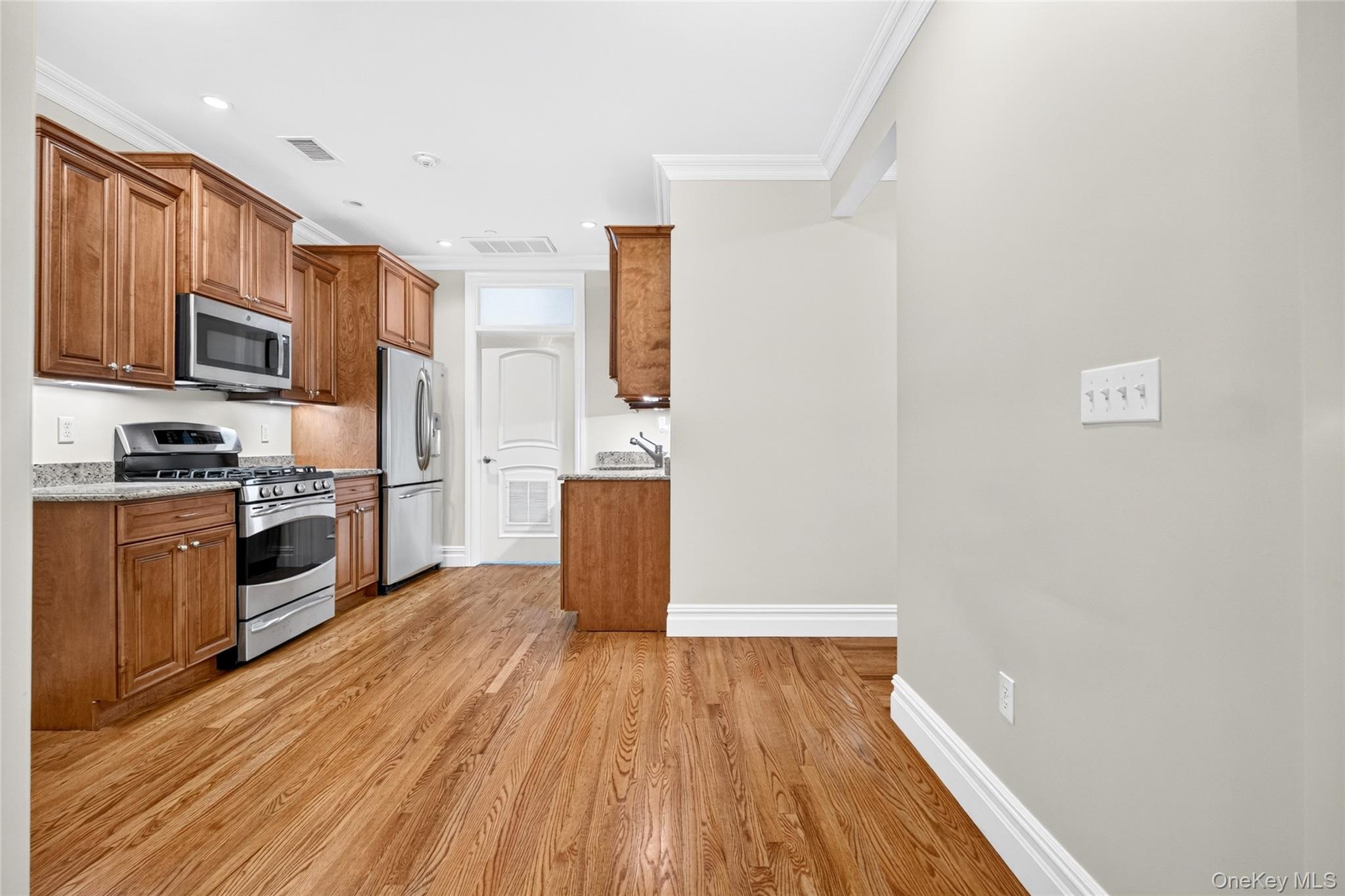 Hardwood flooring, wood cabinetry, granite countertops, stainless steel appliances, and crown molding