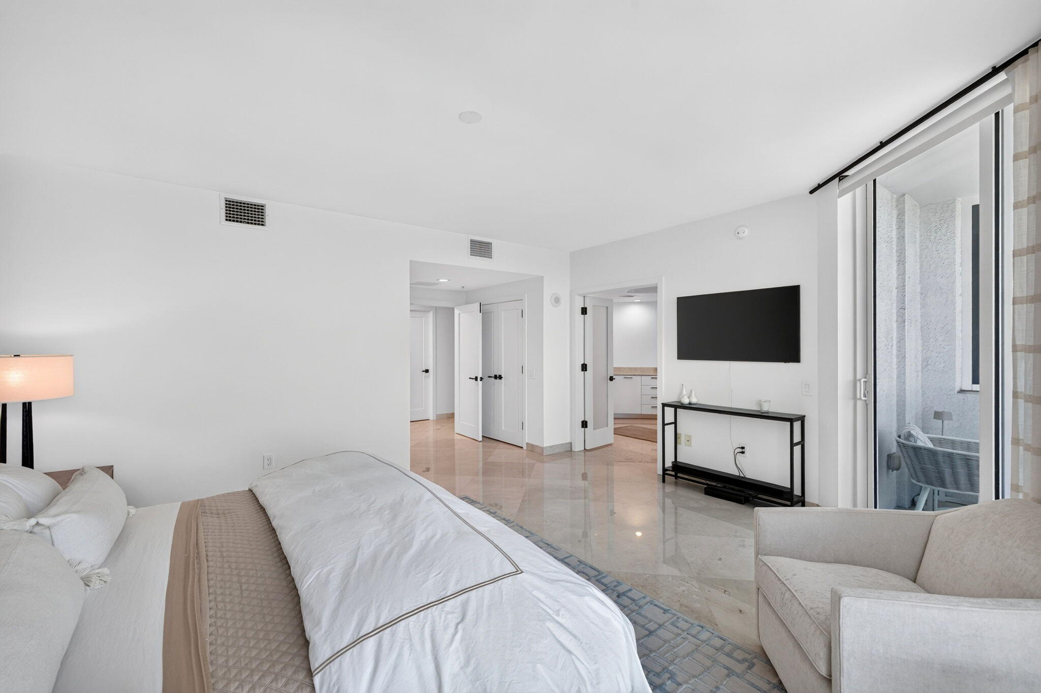 White walls with high ceilings, recessed lighting, and polished stone flooring