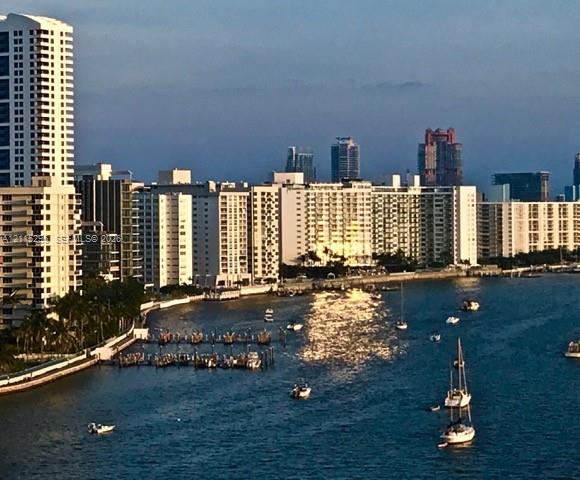 Waterfront urban landscape featuring high-rise architecture, a coastal shoreline, and private deep-water boat slips