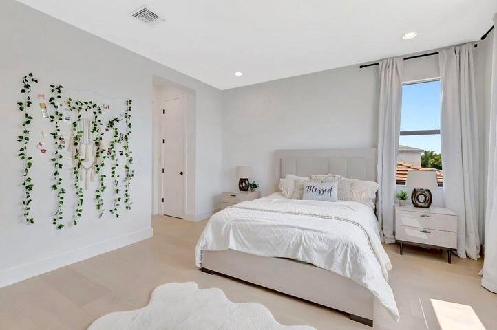 Bright bedroom featuring contemporary styling, oversized windows, and a clean, modern aesthetic.