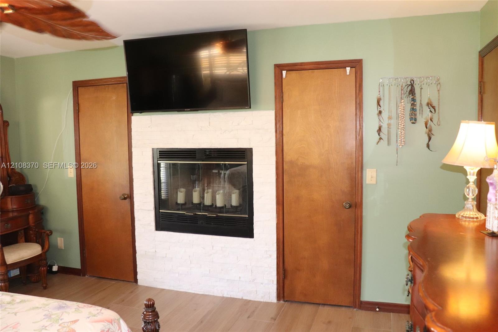 White painted brick fireplace surround, inset firebox, and wood-finish flooring