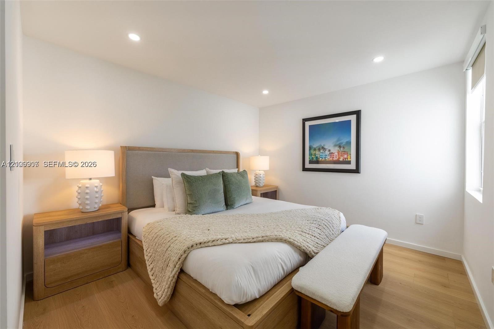 Room featuring wood-finish flooring, recessed lighting, and a window with a roller shade