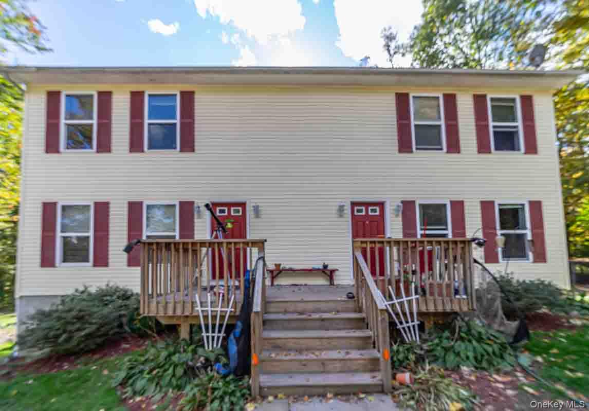 Two-story exterior with light-colored siding and red shutters
