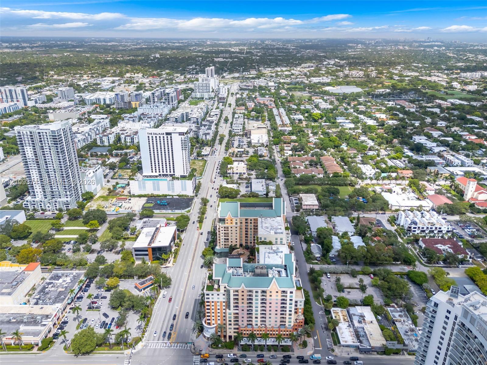 Aerial perspective of a high-rise building complex featuring multi-story residential towers, a structured parking podium, and a central courtyard