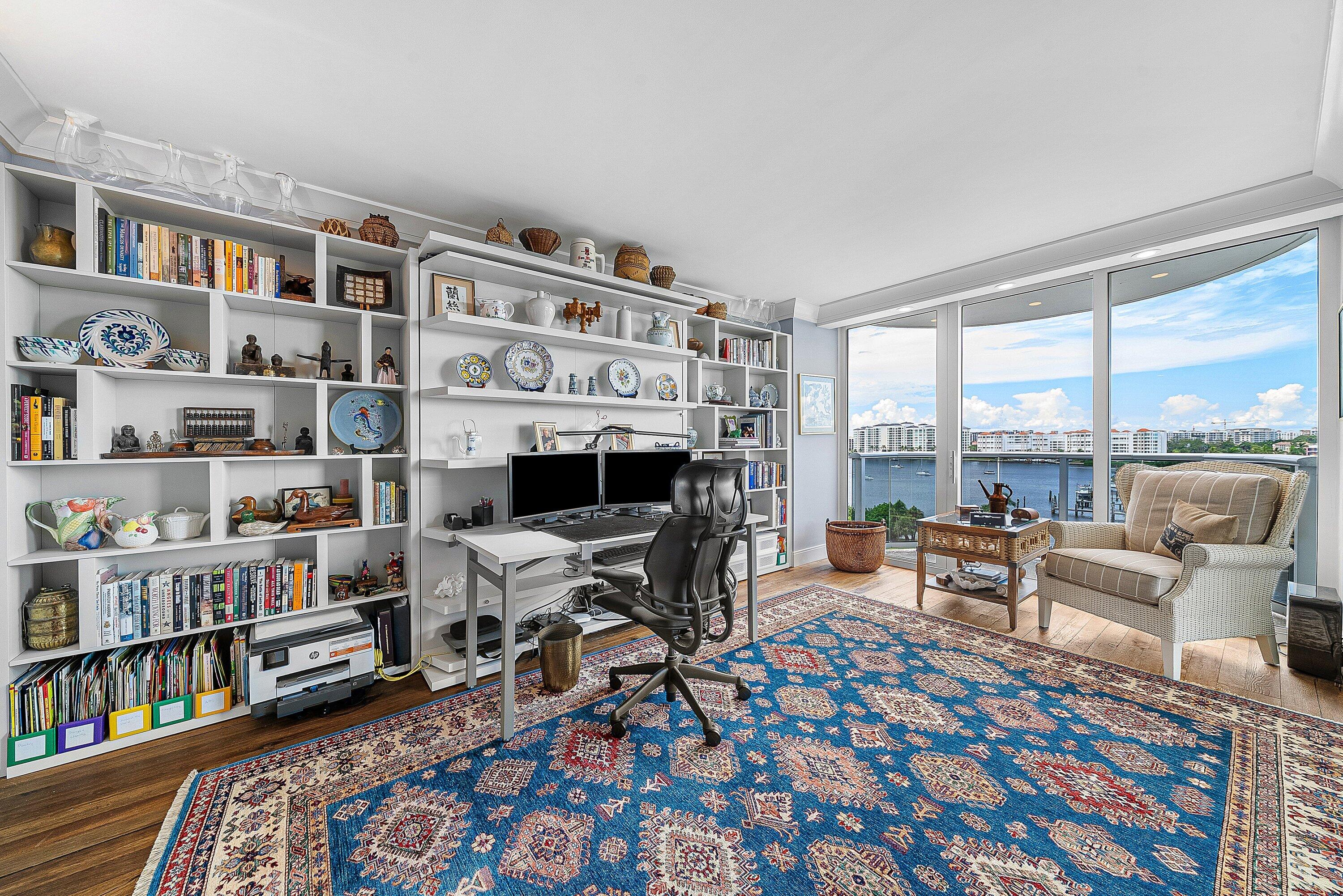 Built-in shelving, wood-finish flooring, full-height windows, and waterfront scenery