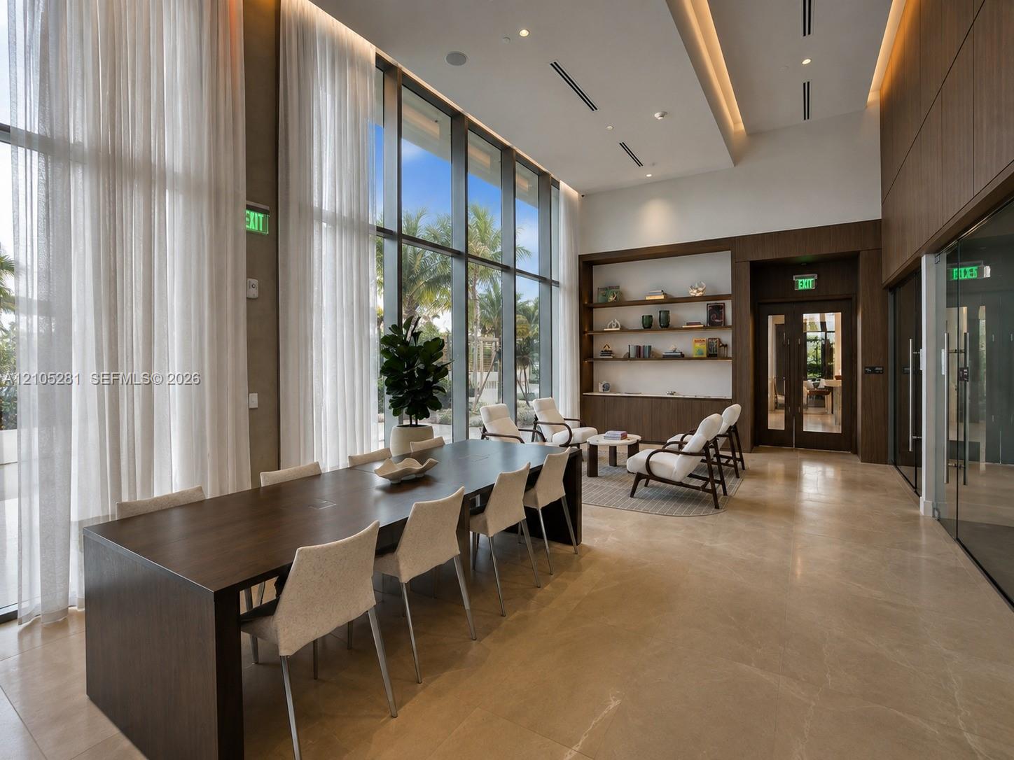 Floor-to-ceiling windows, stone tile flooring, recessed tray ceiling lighting, built-in wooden shelving, and wood-paneled walls