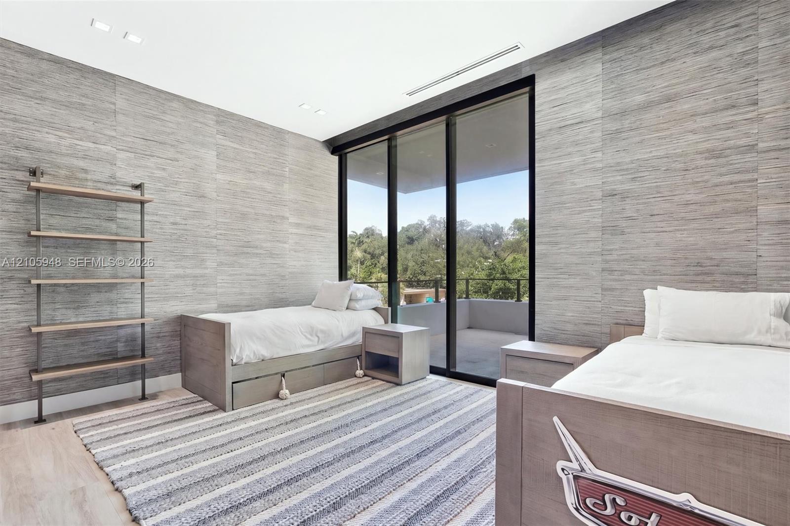 Textured wall surfaces, floor-to-ceiling sliding glass doors, built-in metal shelving, recessed ceiling lighting, and attached balcony