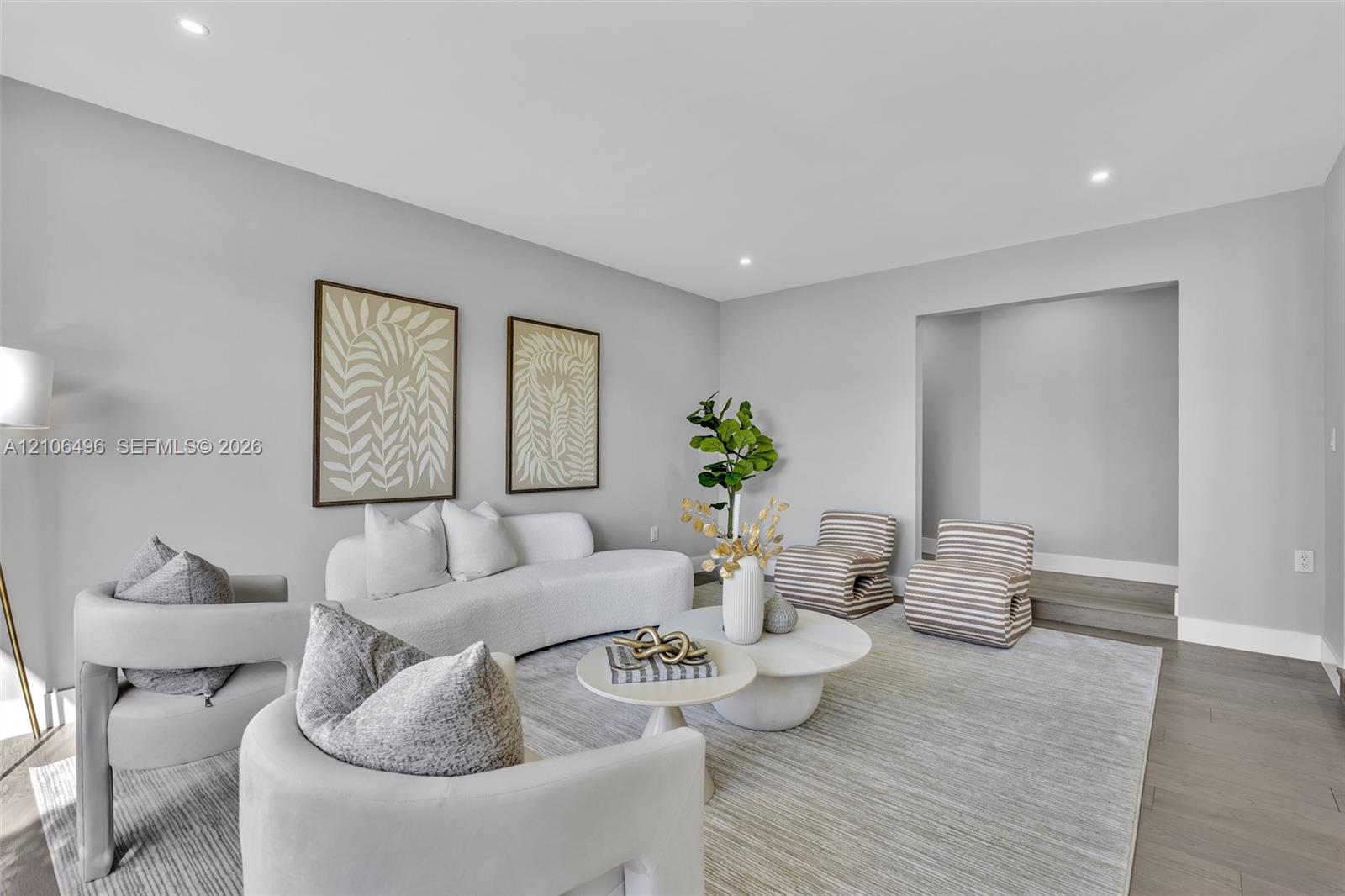 Living area featuring wood-finish flooring, recessed lighting, and a recessed architectural alcove