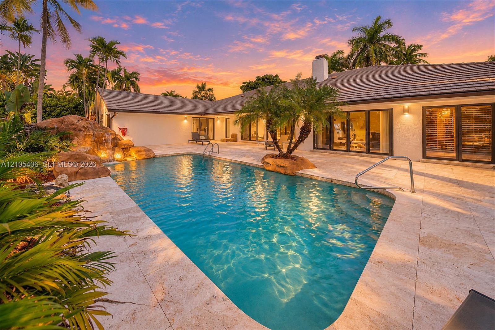 Rectangular swimming pool surrounded by stone paving