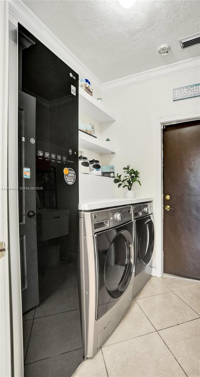 LAUNDRY AREA FEATURES WASHER, DRYER AND STEAM CLOTHING CARE SYSTEM TO STEAM, DEODORIZE AND SANITIZE CLOTHES, BLANKETS, TOYS. DOOR LEADING TO STORAGE/U