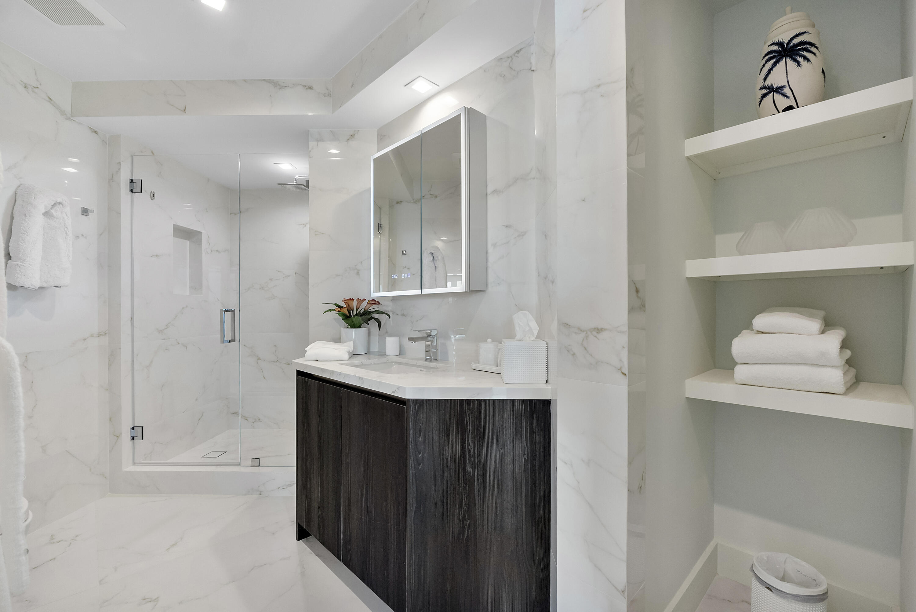 A Private Spa Bath for the Guest Wing — Completing the accommodations is a beautifully appointed en-suite bath, finished in luminous marble-inspired s