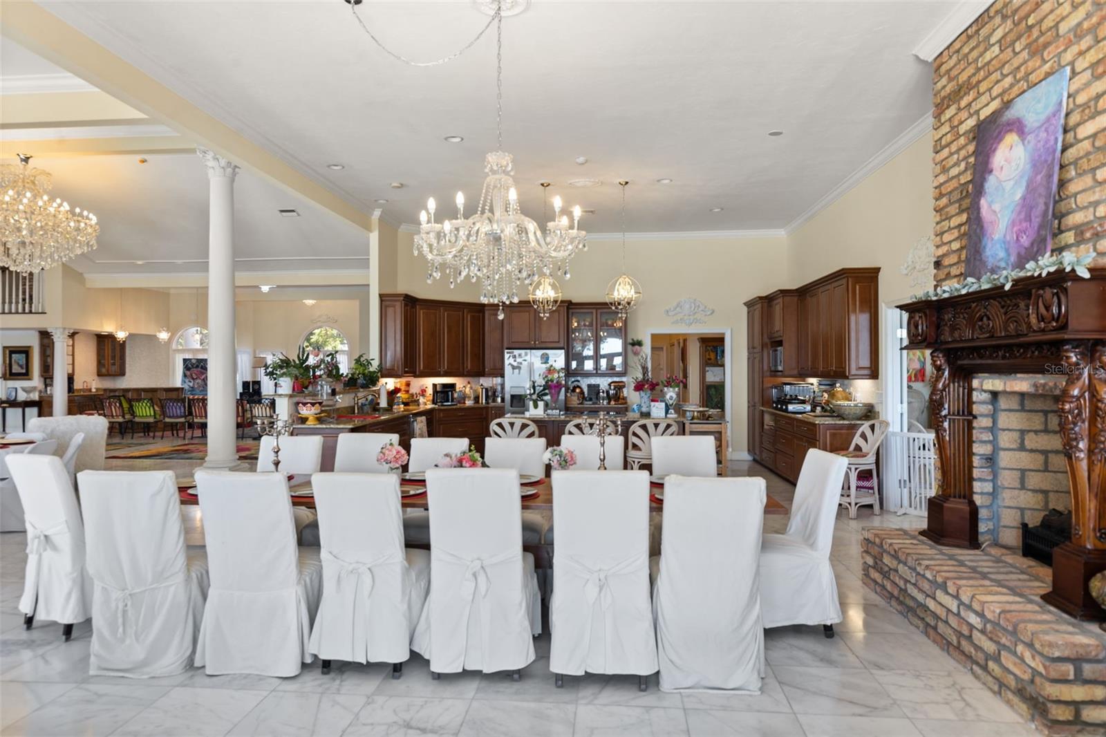 Showcasing the grand kitchen with open views of the family dining area and the ballroom fireplace, creating a rand entertaining.