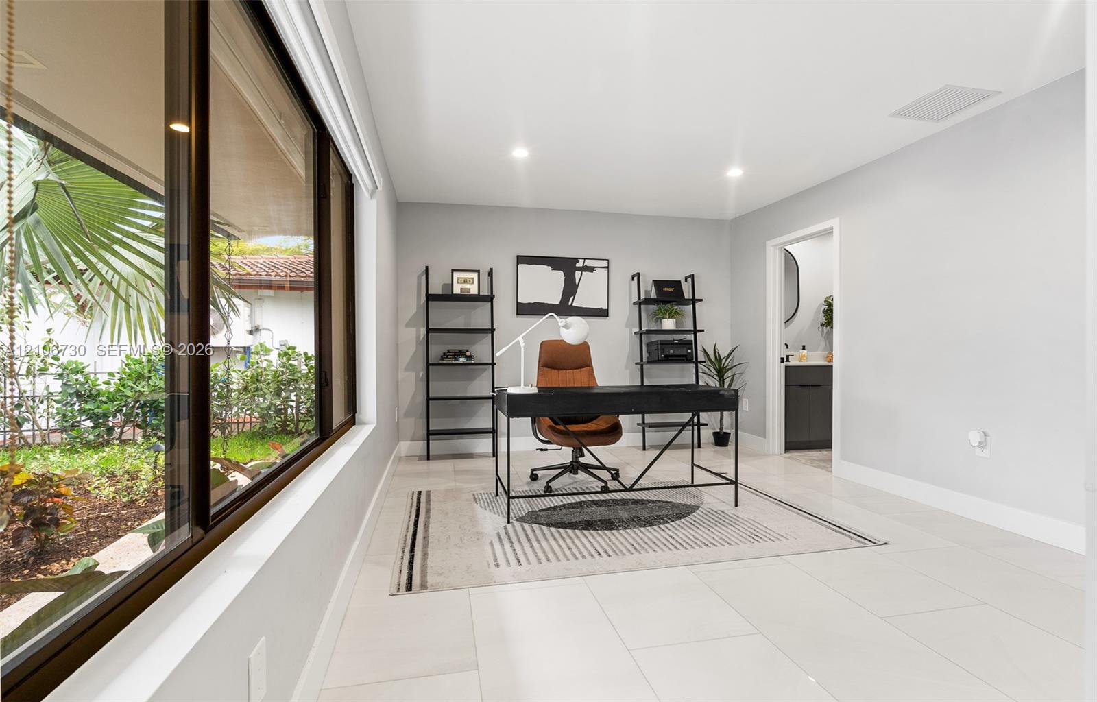 Expansive horizontal window with dark trim, large-format tile flooring, and recessed ceiling lighting