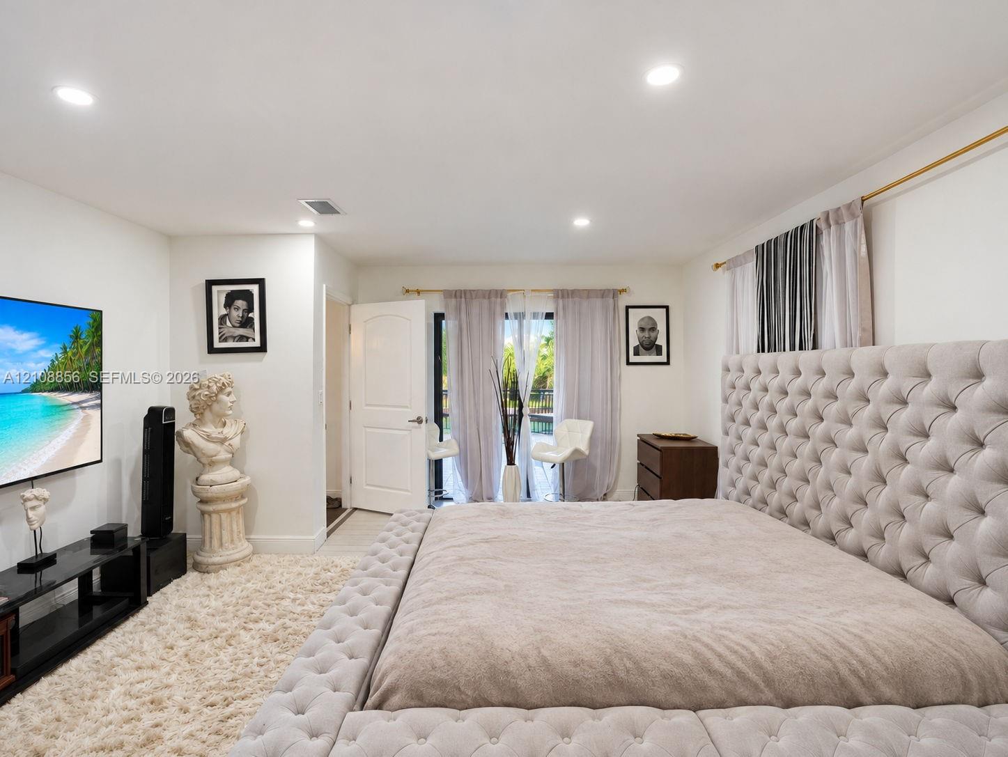 Recessed lighting, smooth walls, and sliding glass doors with gold-tone hardware