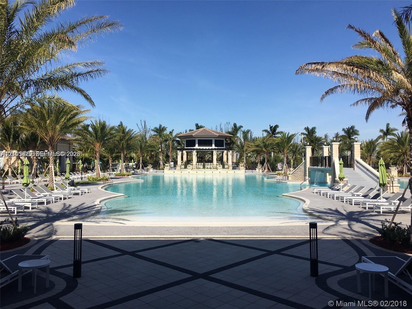 Swimming pool featuring a beach-style entry, a central gazebo, stone-tiled decking, a decorative water feature, and integrated landscape lighting