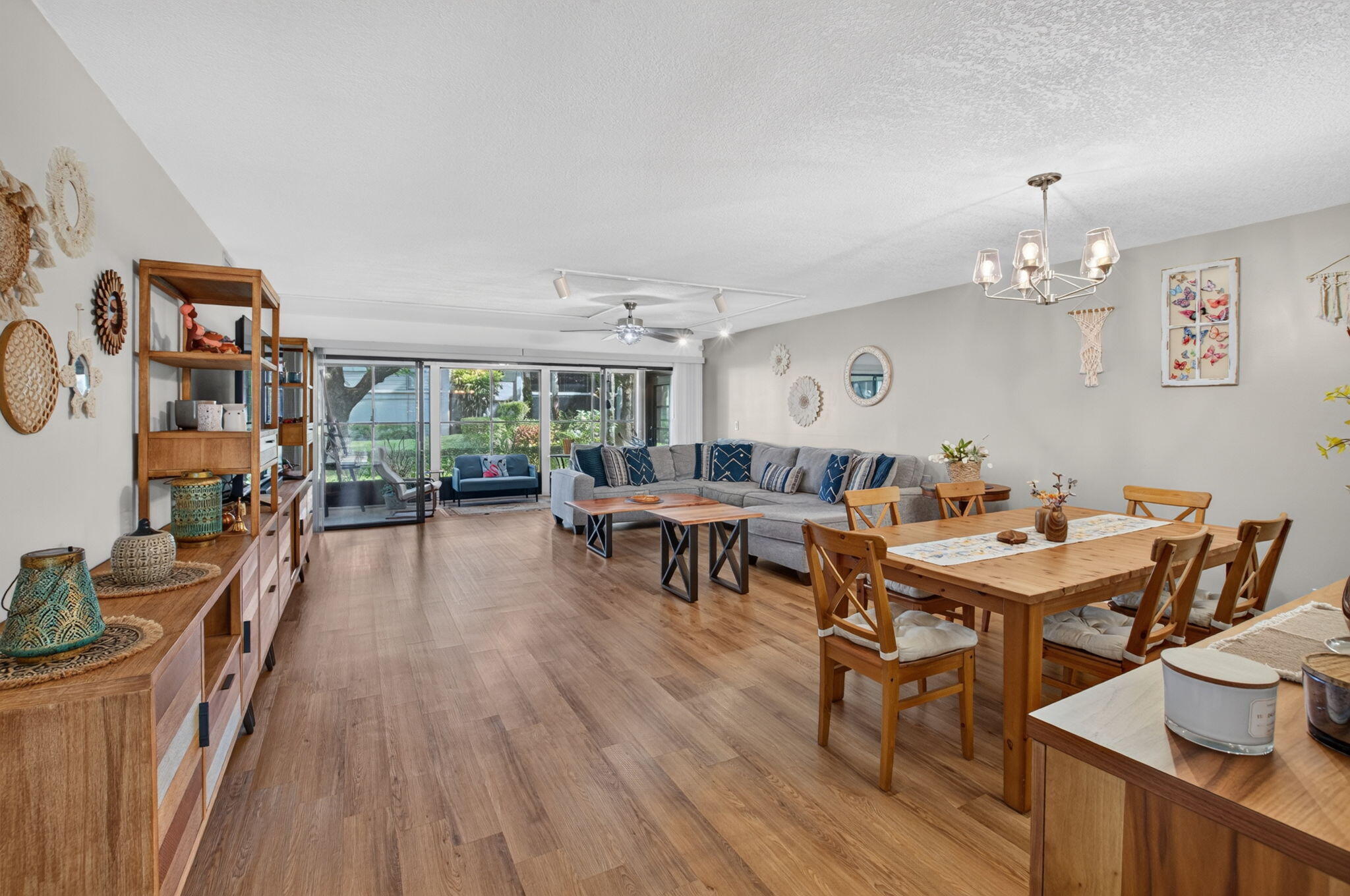 Expansive main living area featuring wood-finish flooring, and a contemporary chandelier