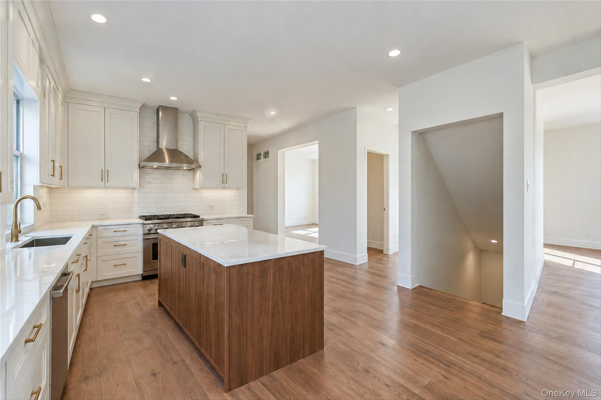 Virtually Staged - Kitchen. First Floor will have hardwoods. Kitchen cabinets in white/dove color. Island will be similar to the hardwoods.