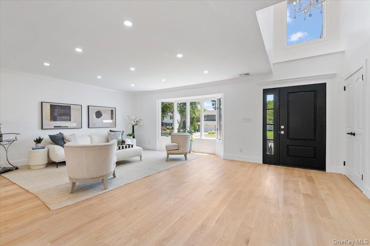 Foyer featuring light wood-style flooring, crown molding, recessed lighting, and a chandelier