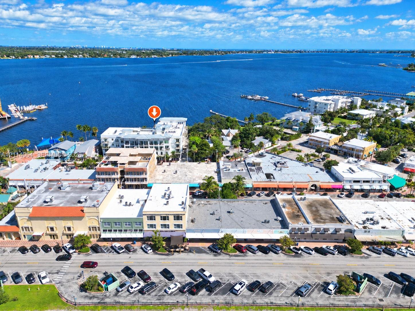 Aerial perspective of waterfront property featuring multi-story building architecture, direct proximity to open water, and localized street-level park