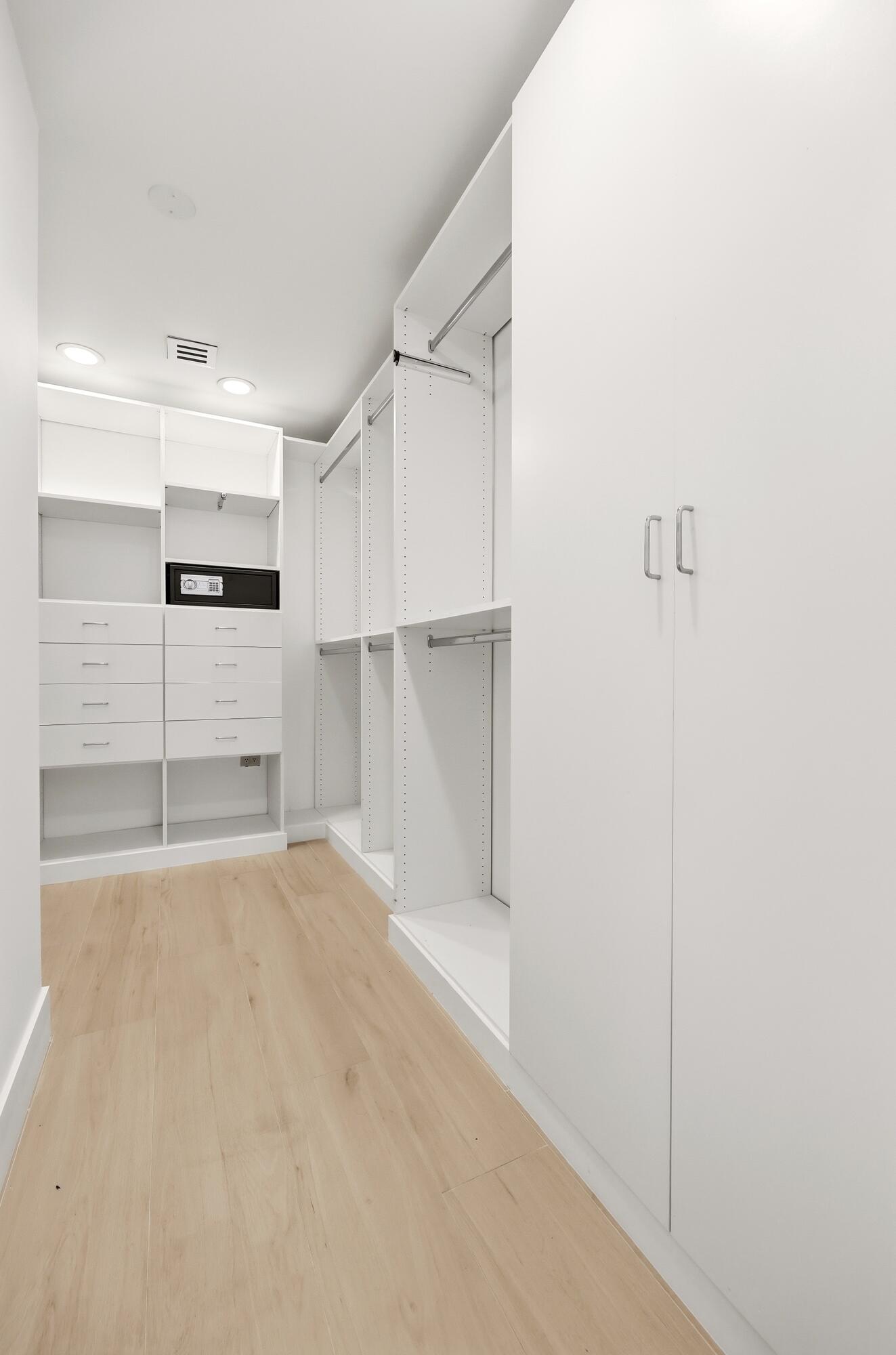 Designed for organization and convenience, this custom walk-in closet offers an impressive amount of storage with built-in shelving, abundant hanging