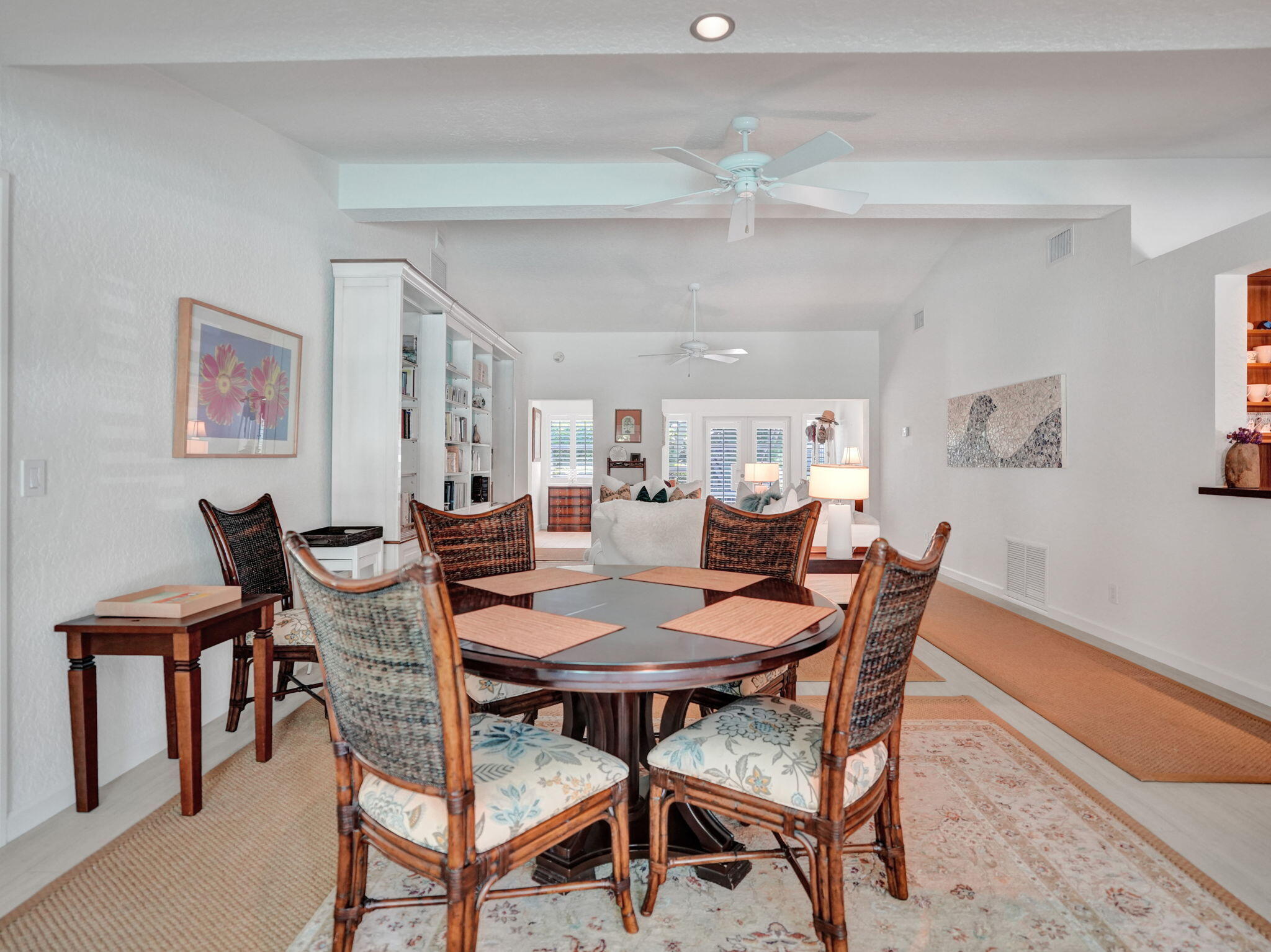 Vaulted ceilings with exposed beams, recessed lighting, and a ceiling fan