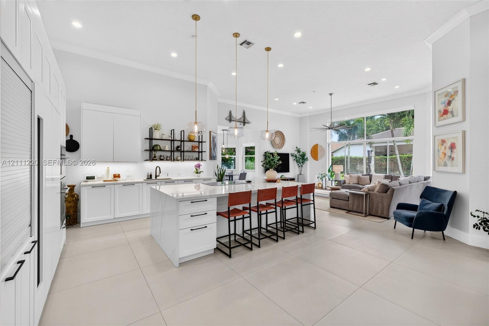Kitchen featuring a large central island with quartz surfacing, floor-to-ceiling white cabinetry, matte black hardware, recessed lighting, and large-f