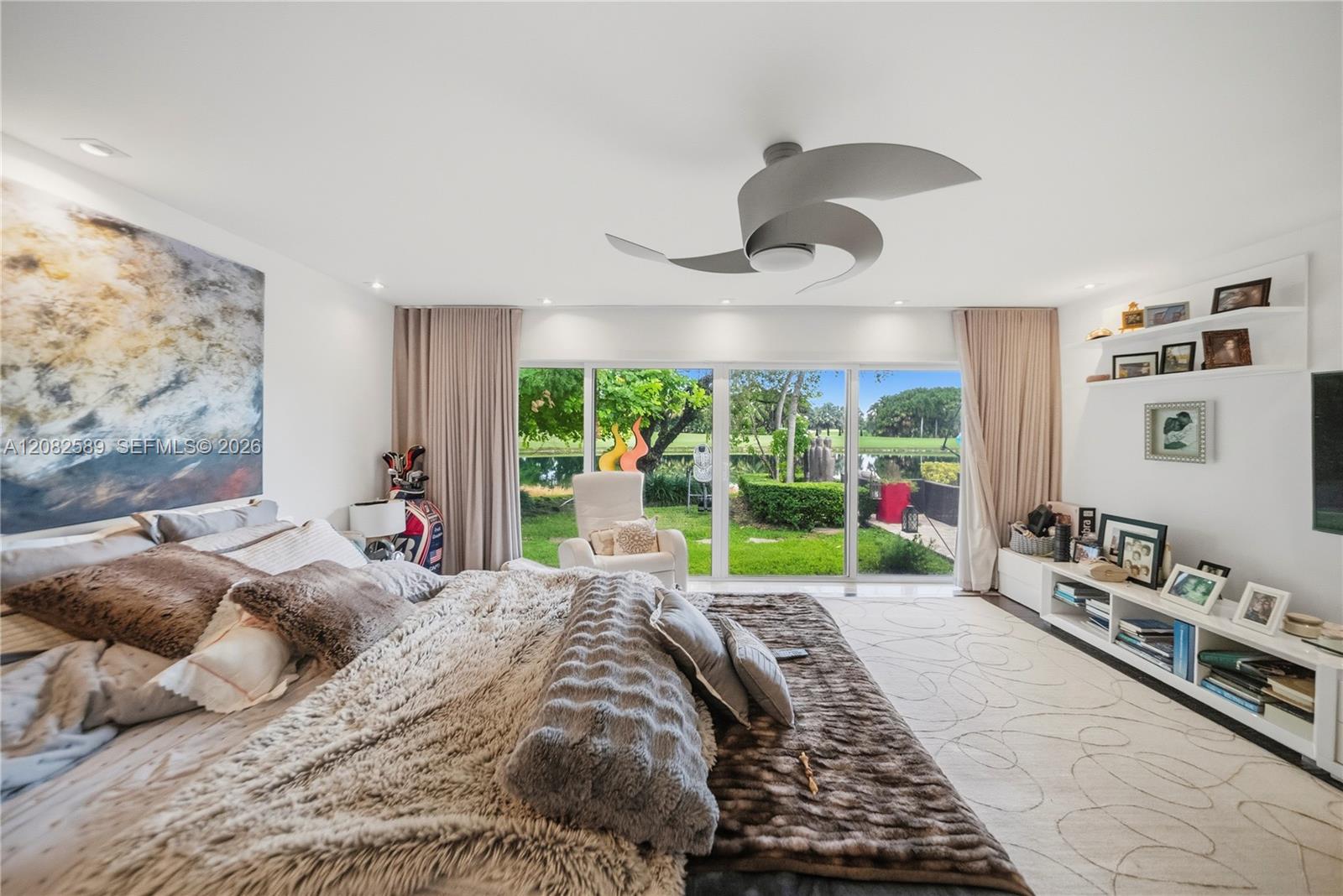 Spacious primary bedroom featuring floor-to-ceiling glass doors and serene water views.