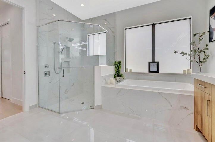 Spa-inspired primary bath featuring a frameless glass walk-in shower, modern finishes, and a clean, contemporary design.