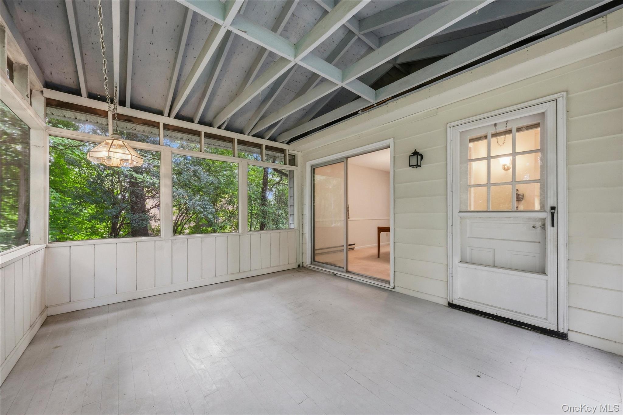 Screened porch overlooks wooded backyard
