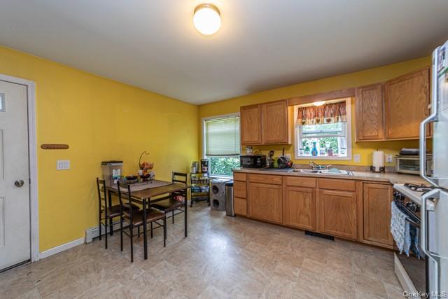 Kitchen featuring wood-finish cabinetry, a stainless steel sink, and a four-burner gas range