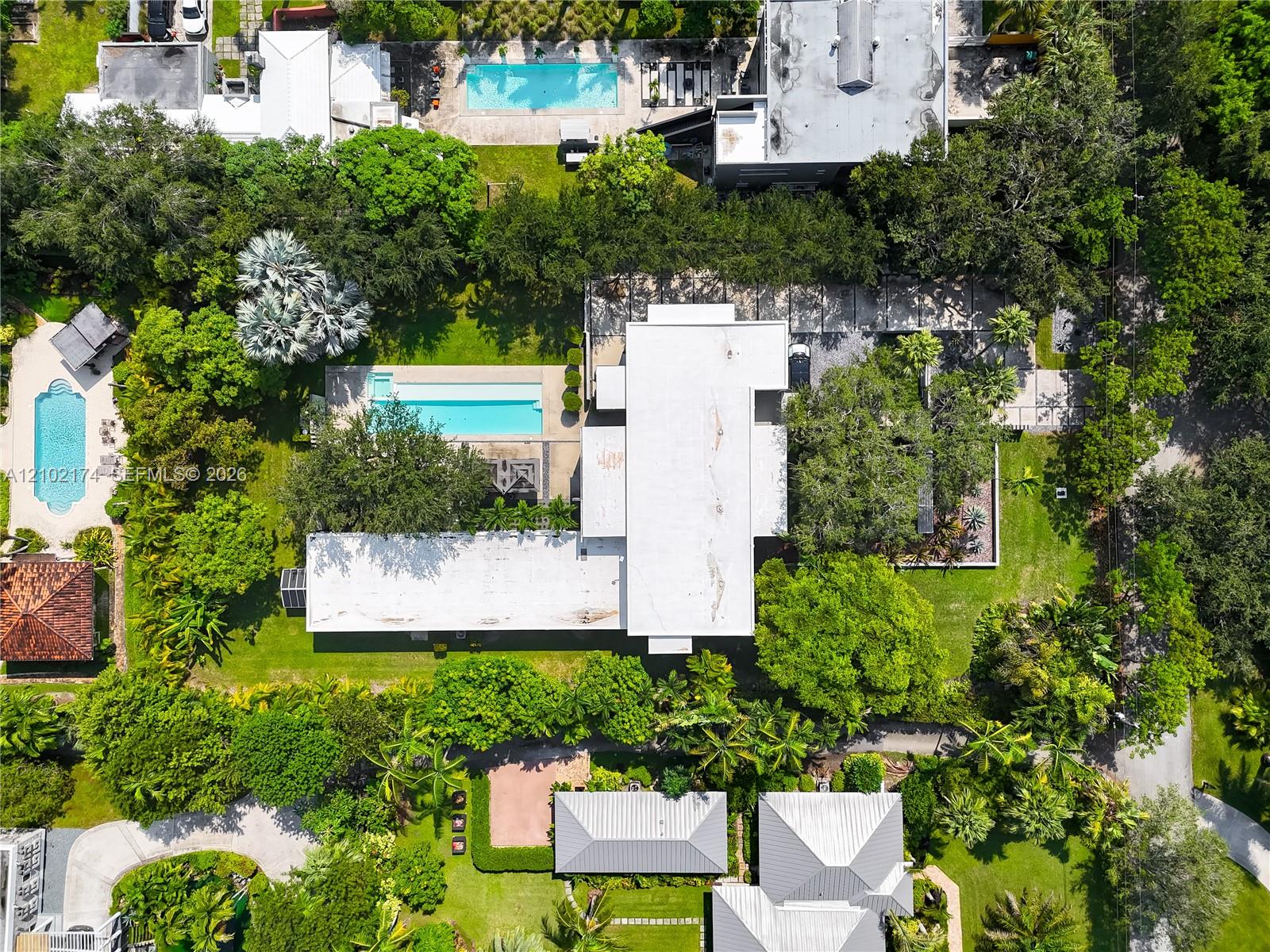 Aerial perspective of a low-density residential neighborhood characterized by mature tree canopy and established vegetation