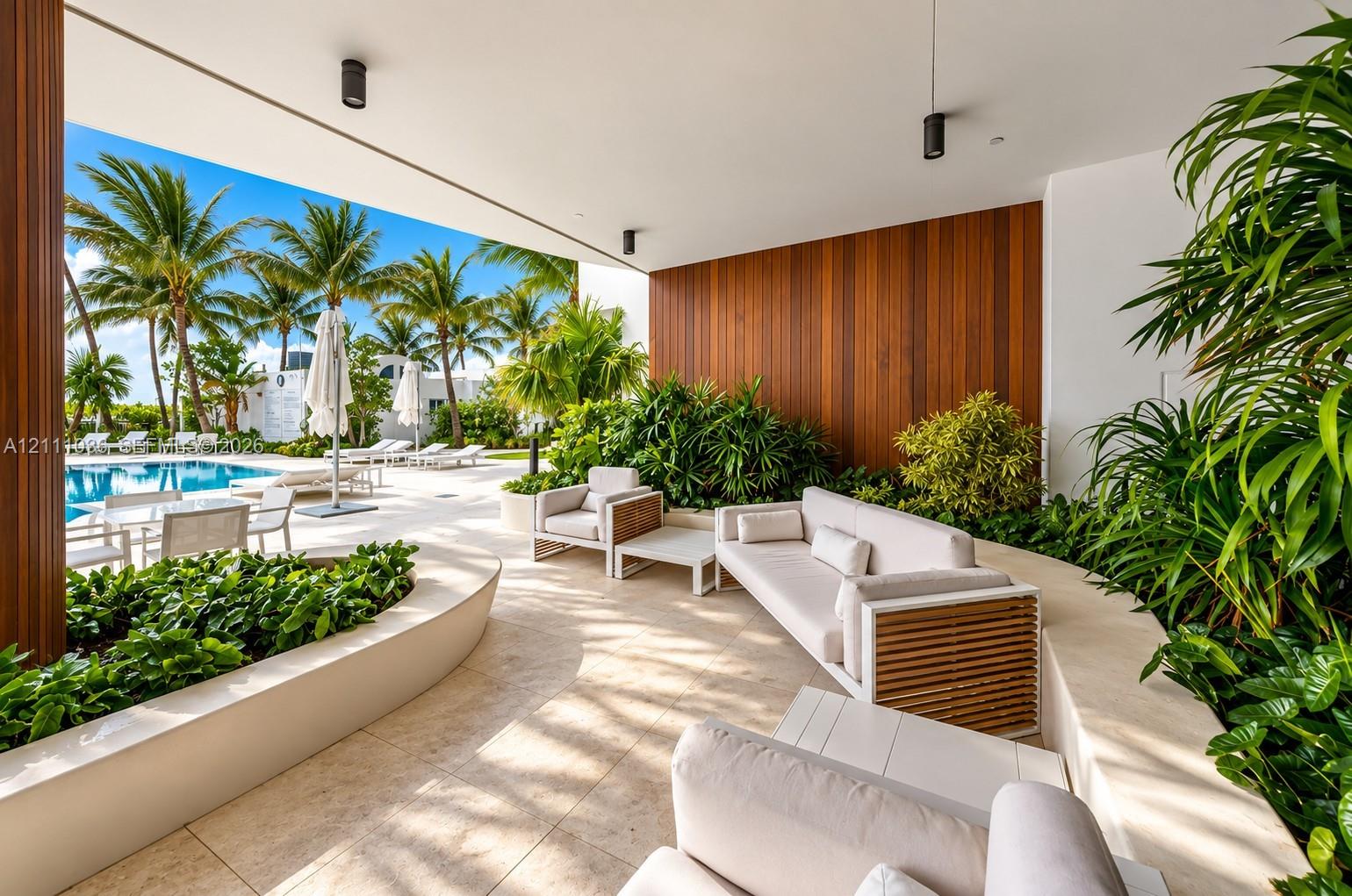 Covered patio featuring large-format stone tile flooring, vertical wood-panel accent wall, integrated recessed lighting, and built-in curved stone pla