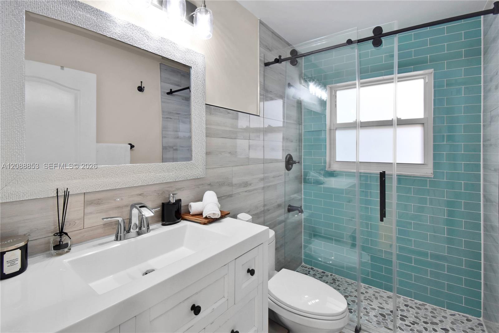 Updated bathroom with new vanity and fixtures, and glass-enclosed shower