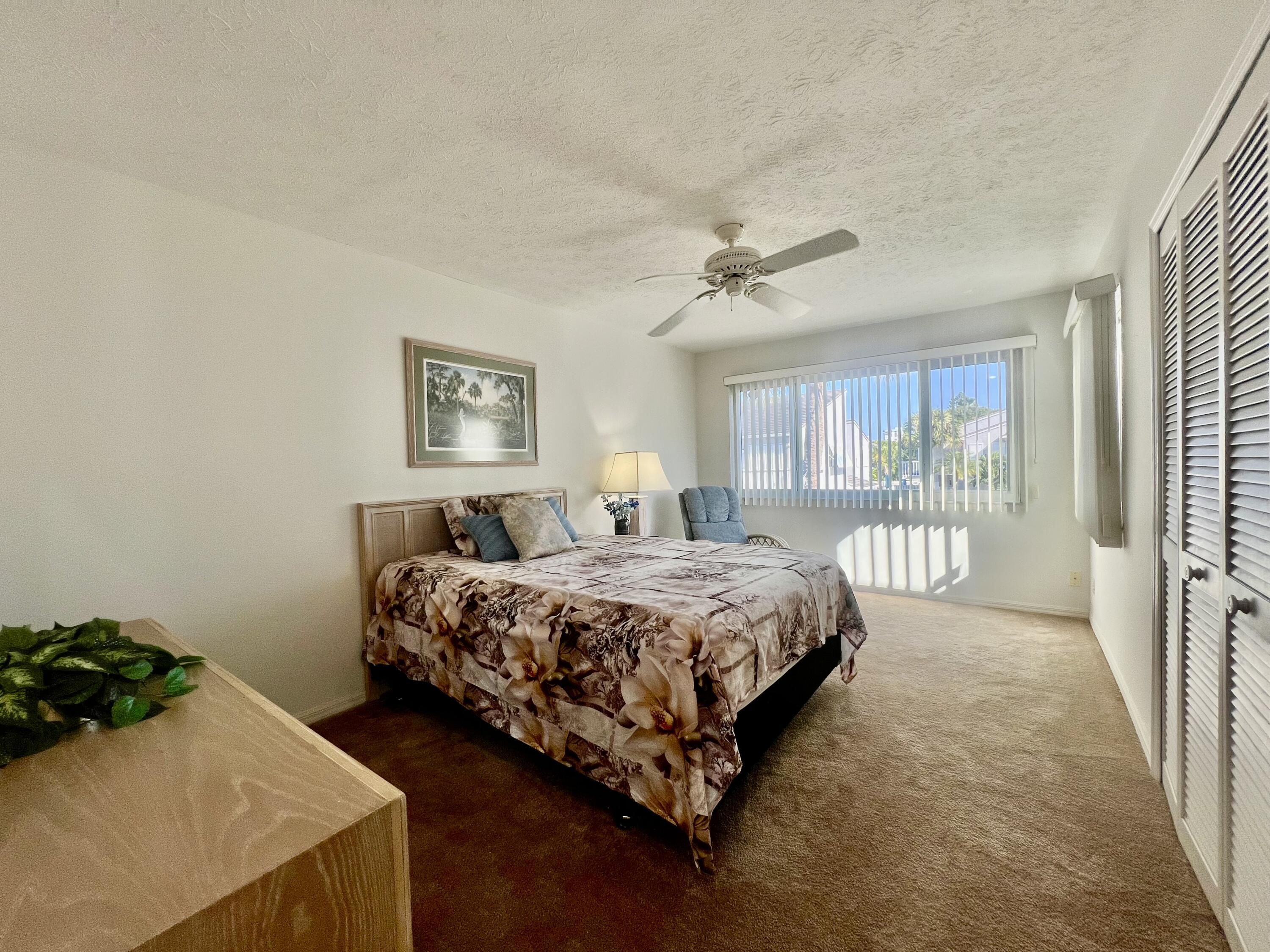 Ceiling fan, window with vertical blinds, and louvered bifold closet doors