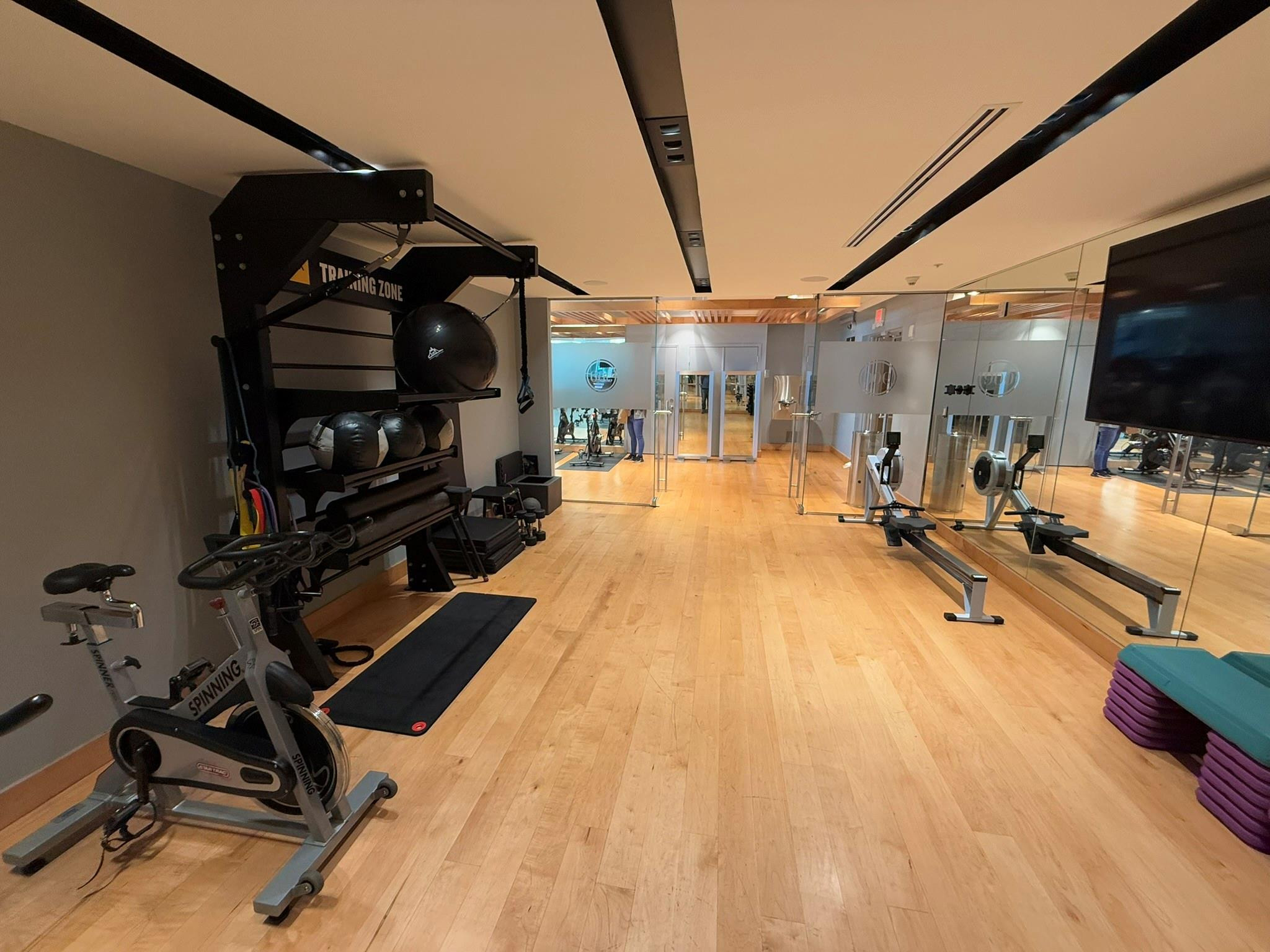 Dedicated fitness area featuring light wood-finish flooring