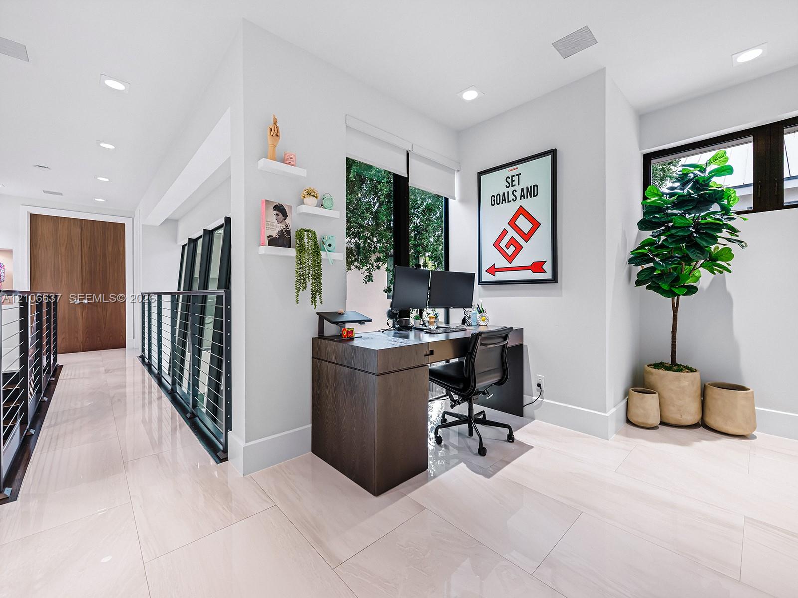 Light-toned large-format tile flooring, recessed ceiling lighting, metal cable railing system, and tall windows with dark trim