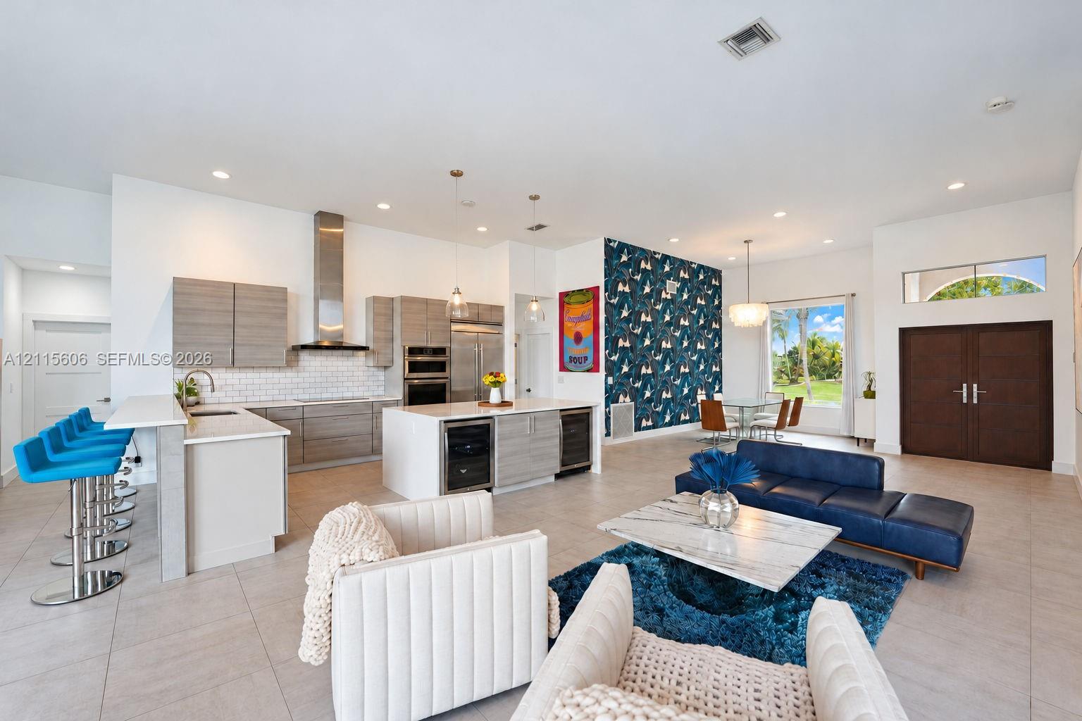 Open-concept living space featuring a gourmet kitchen with horizontal-grain cabinetry, quartz countertops, a stainless steel chimney-style range hood,