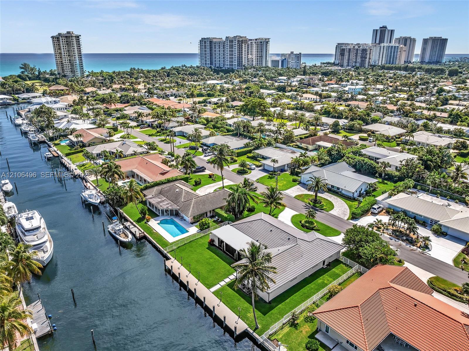 Waterfront residential property featuring private canal access, a concrete bulkhead, paved patio area, and a rectangular swimming pool
