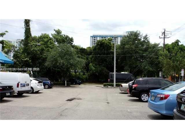 Paved surface lot featuring mature perimeter landscaping and an integrated utility pole