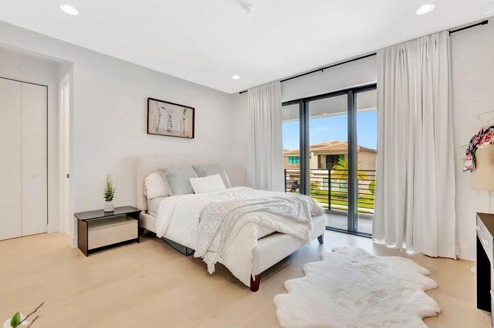Comfortable bedroom with wide-plank flooring, recessed lighting, and a calm, neutral palette.