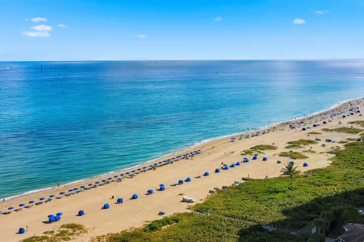 Expansive beachfront with clear blue water and sandy shores